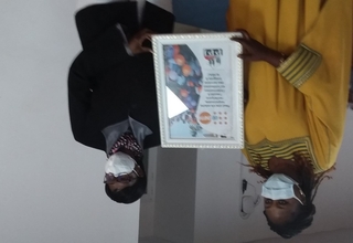 La Coordonnatrice nationale de PPJ, Mme Coura Gaam Diouf remettant à Mme la RR, Cécile Compaoré Z, un tableau magnifiant le travail de UNFPA, le 9/02/2021, Salle Almadie 1 (photo UNFPA Senegal)