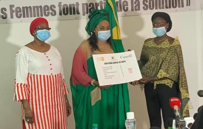 La Ministre de la femme au centre remet à la bénéficiaire à droite la contribution reçue de UNFPA